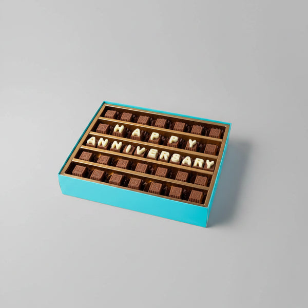 Box of chocolates with 'Happy Anniversary' message on a light background