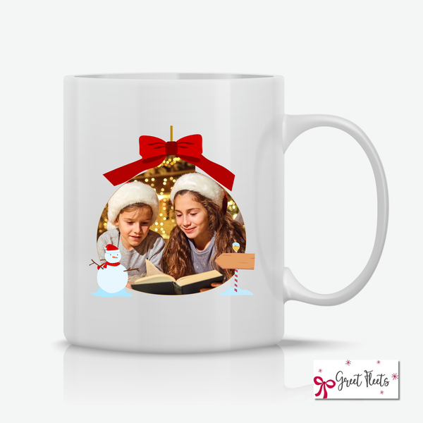 White mug with a Christmas-themed design featuring two children, a red bow, and a snowman on a white background.
