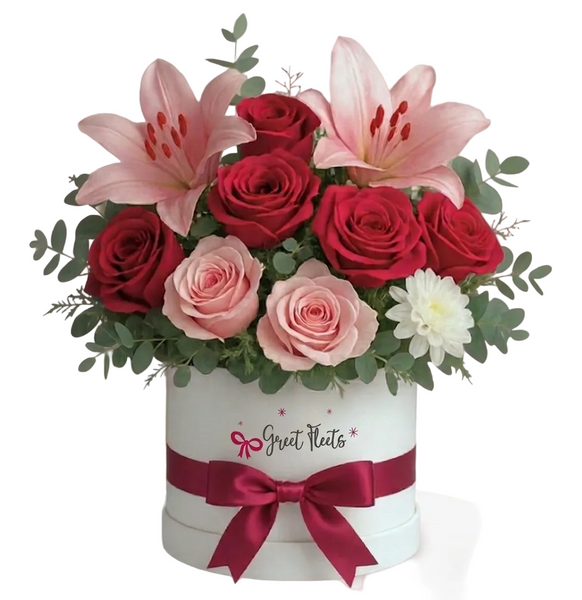 Floral arrangement with red roses, pink lilies, and pink roses in a white box with a red ribbon, branded 'Great Fleets'.